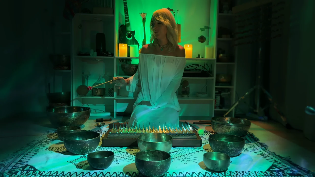 Viktoria reaching toward a Tibetan singing bowl beside the kalimba.