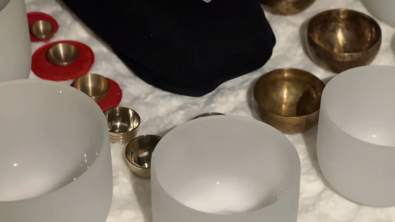 White crystal and metal singing bowls viewed from above.